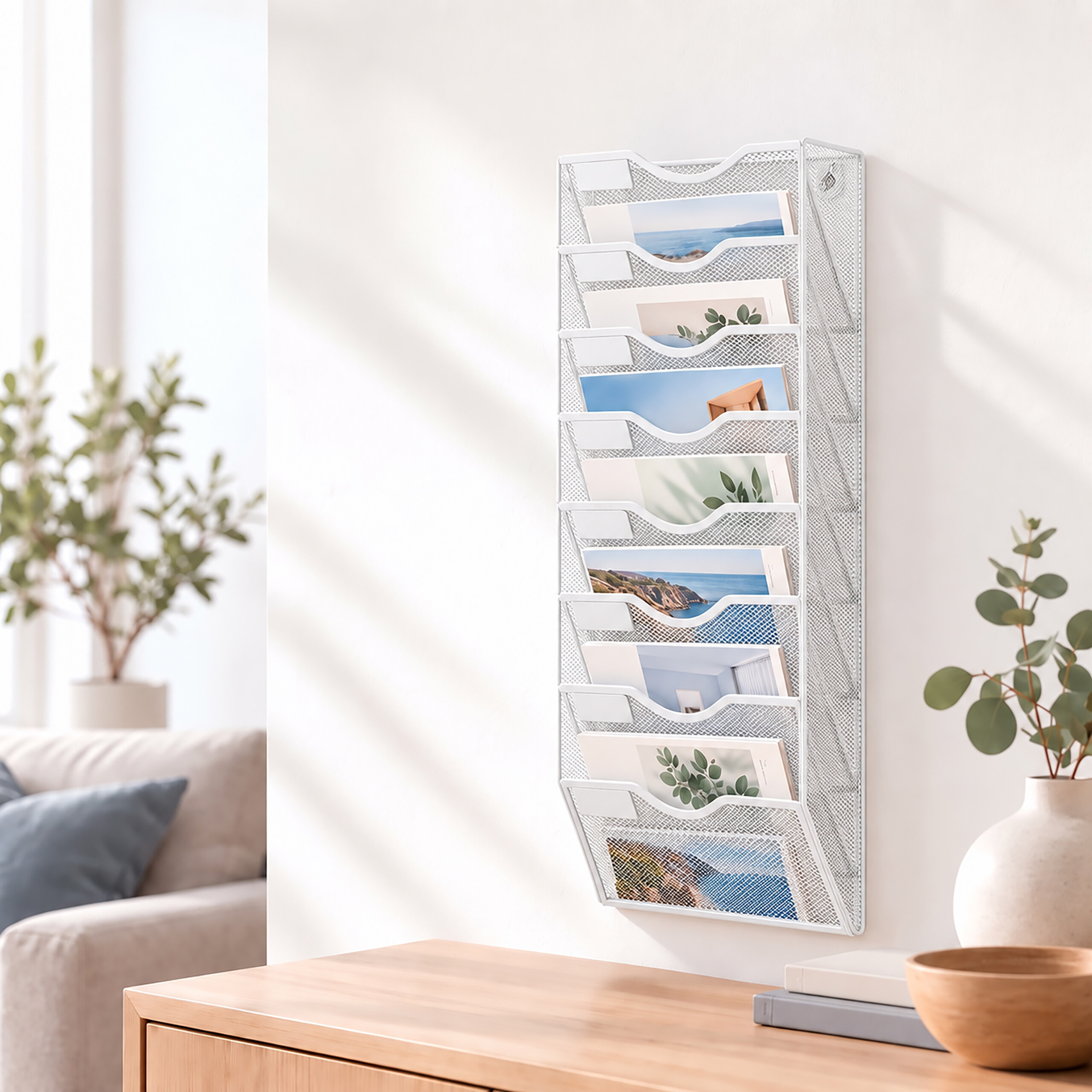 Ein weißer Wandorganizer mit Zeitschriften hängt an einer hellen Wand über einem Holztisch.