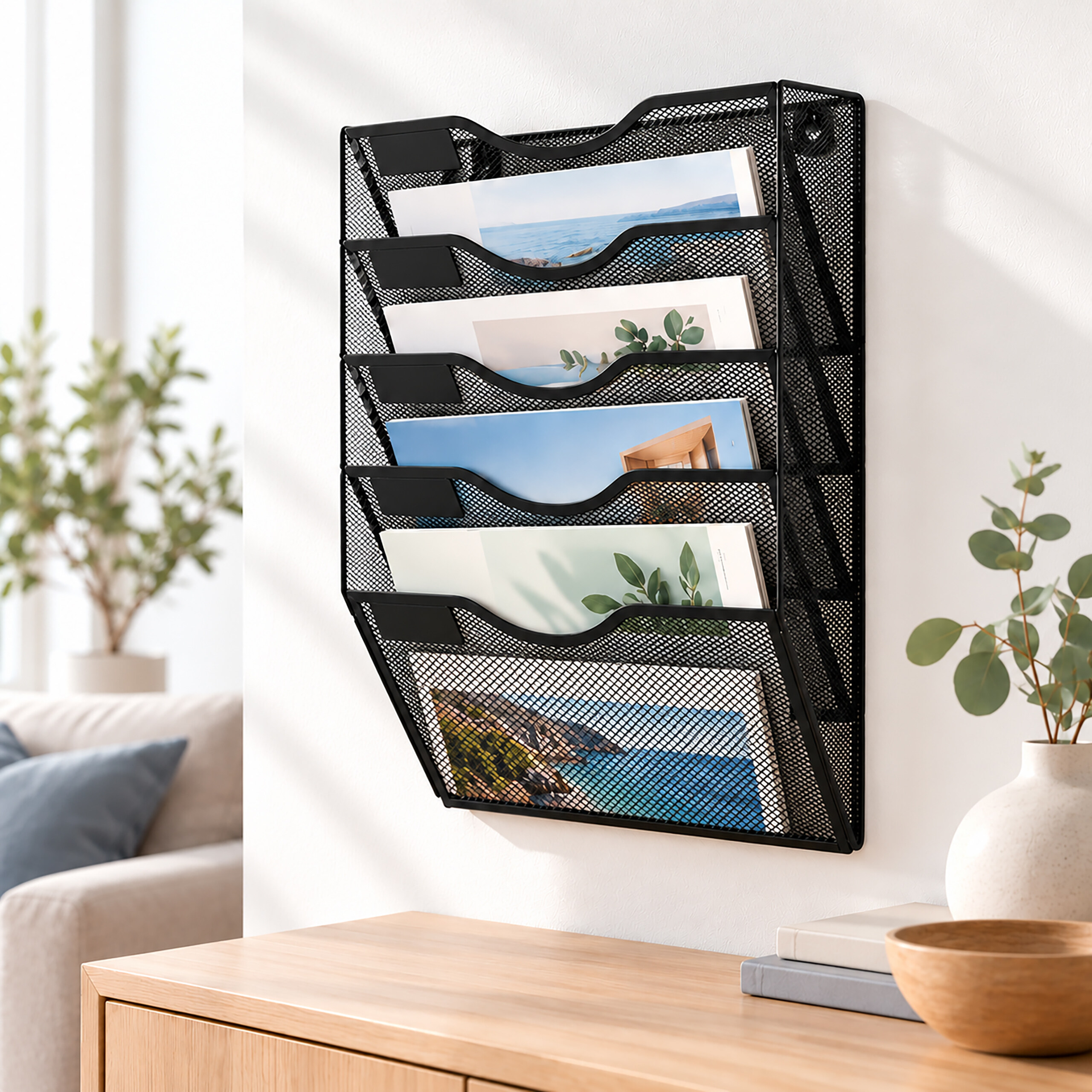 Ein schwarzer Wandorganizer aus Metall mit bunten Zeitschriften hängt über einem Holztisch.