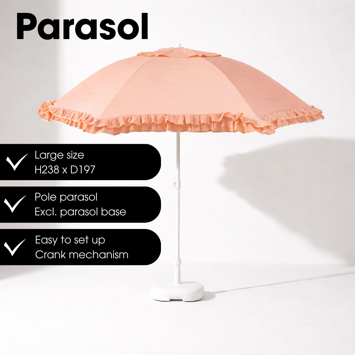 A peach-colored parasol with a ruffled edge and white pole stands on a white floor against a white wall.