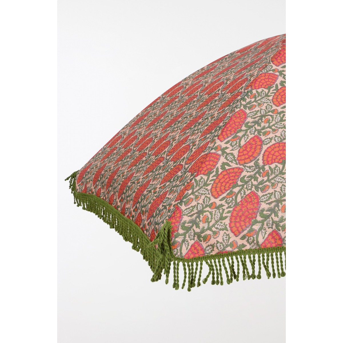 A close-up of a pink umbrella with red floral patterns and green fringe.