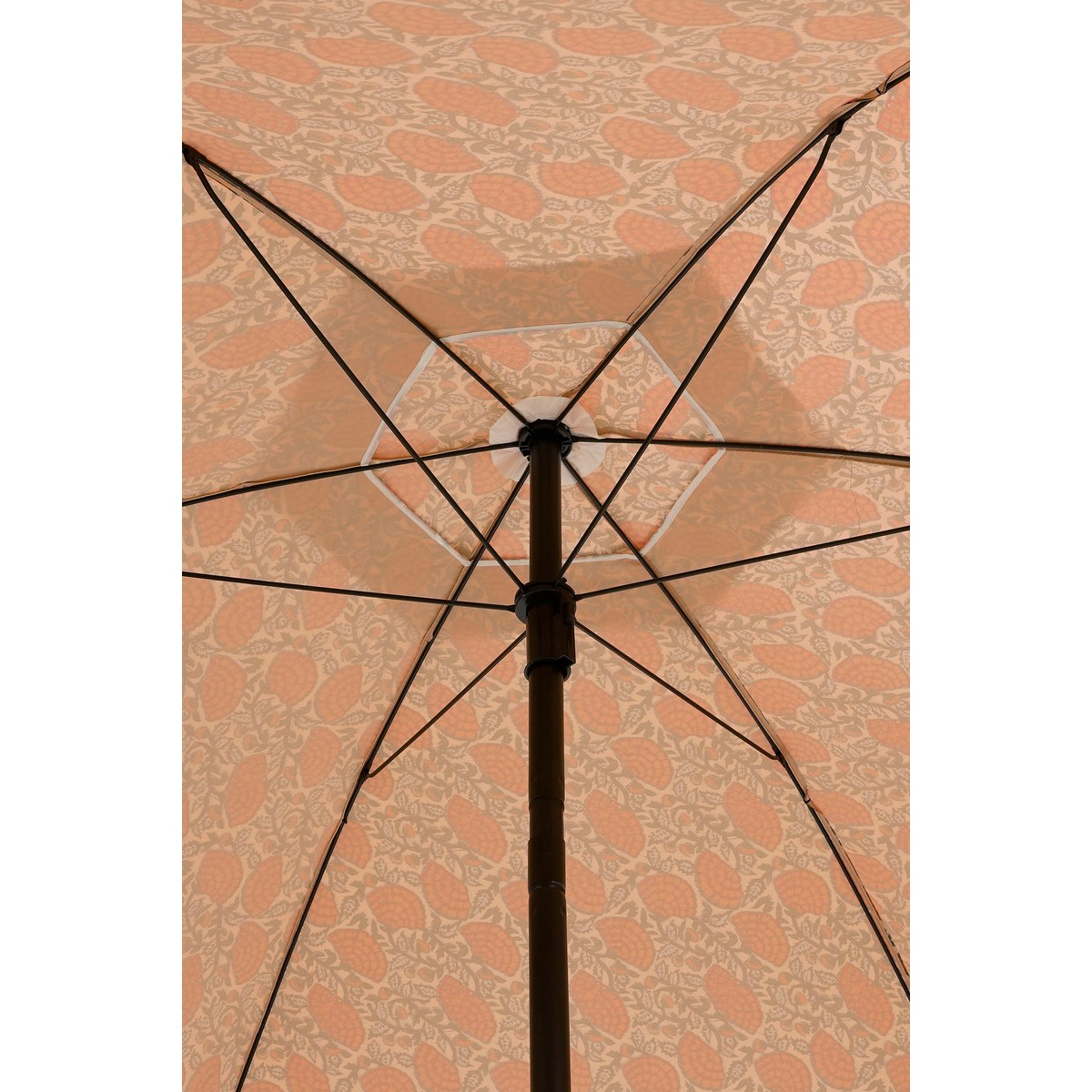 Bottom-up view of an open umbrella, showing its black metal frame and peach-colored patterned fabric.