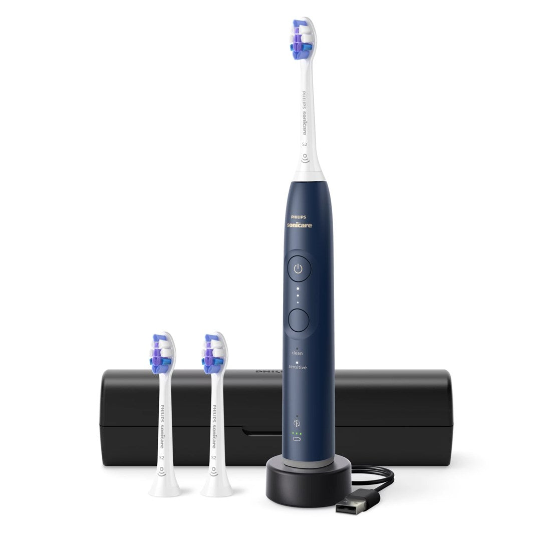 Dunkelblaue Philips Sonicare elektrische Zahnbürste mit Ladebasis, zwei Ersatzbürsten und schwarzem Etui auf weißem Grund.