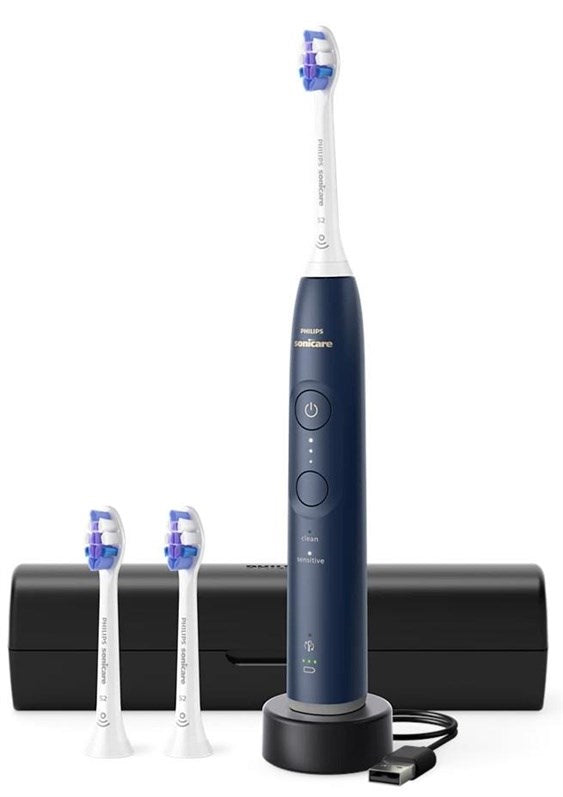 Eine dunkelblaue Philips Sonicare elektrische Zahnbürste steht auf einer Ladestation neben zwei Ersatzköpfen und einem Etui.