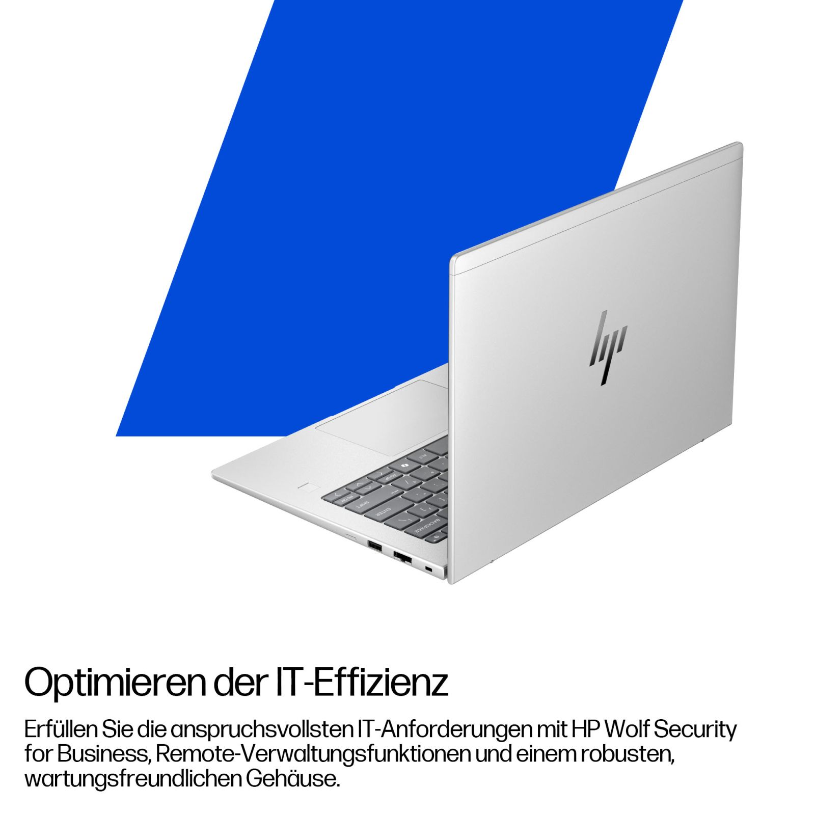Ordinateur portable argenté sur fond bleu avec du texte en allemand sur l'informatique.