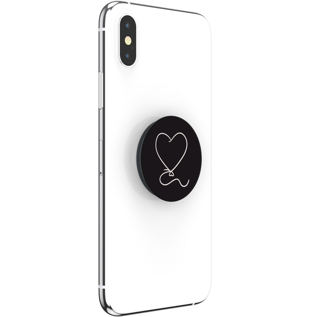 Ein weißes Smartphone mit einem schwarzen runden Halter auf der Rückseite, der ein weißes Herzsymbol zeigt.