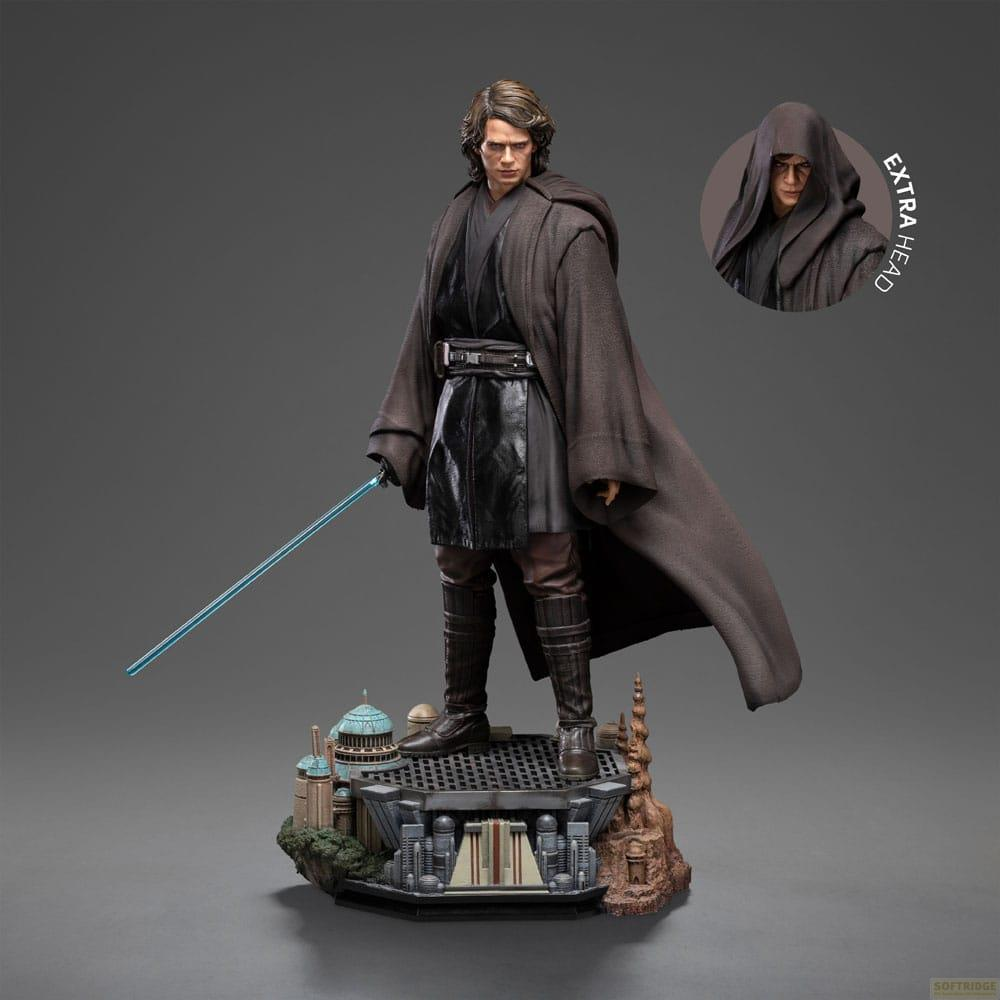 Figura di Anakin Skywalker con tunica marrone, spada laser blu e base. Testa incappucciata extra.