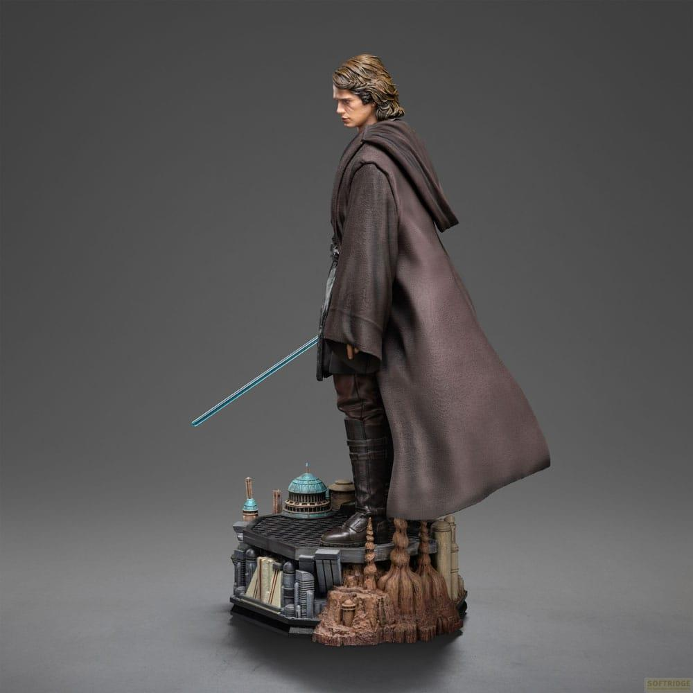 Figura di Anakin Skywalker con mantello marrone e spada laser blu su base diorama.