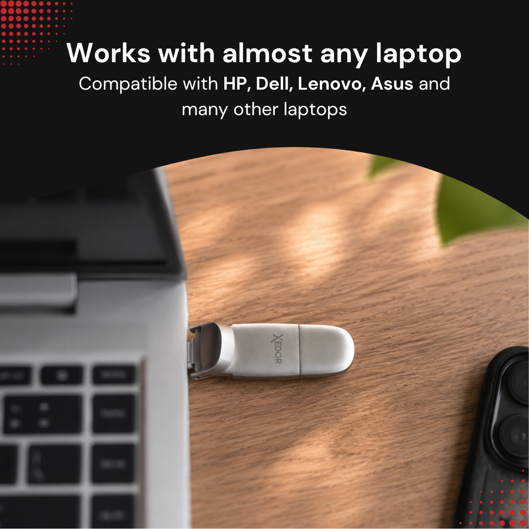 Srebrny pendrive podłączony do laptopa na drewnianym biurku.