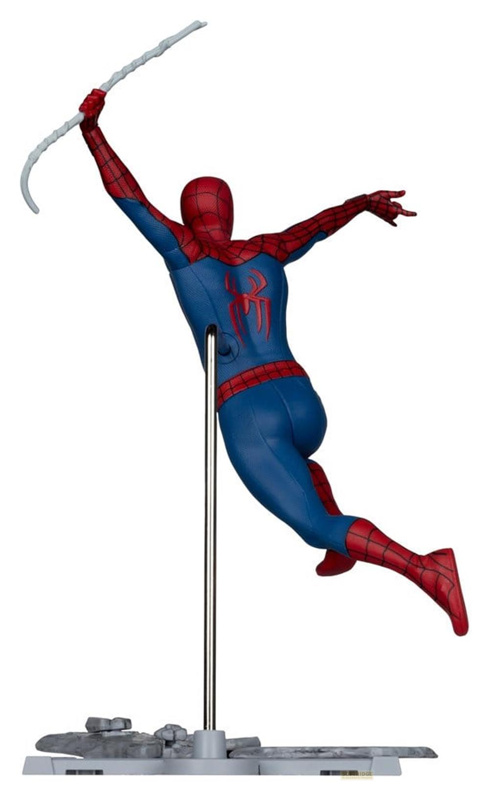 Un'action figure di Spider-Man rossa e blu è montata su un'asta di metallo su una base grigia, mentre tiene una ragnatela.
