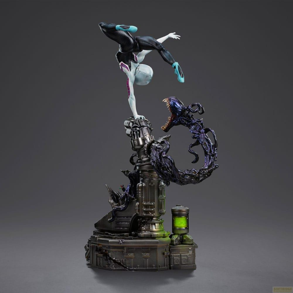 Action figure di Ghost-Spider in verticale su base tecnologica mentre una creatura simbionte attacca.