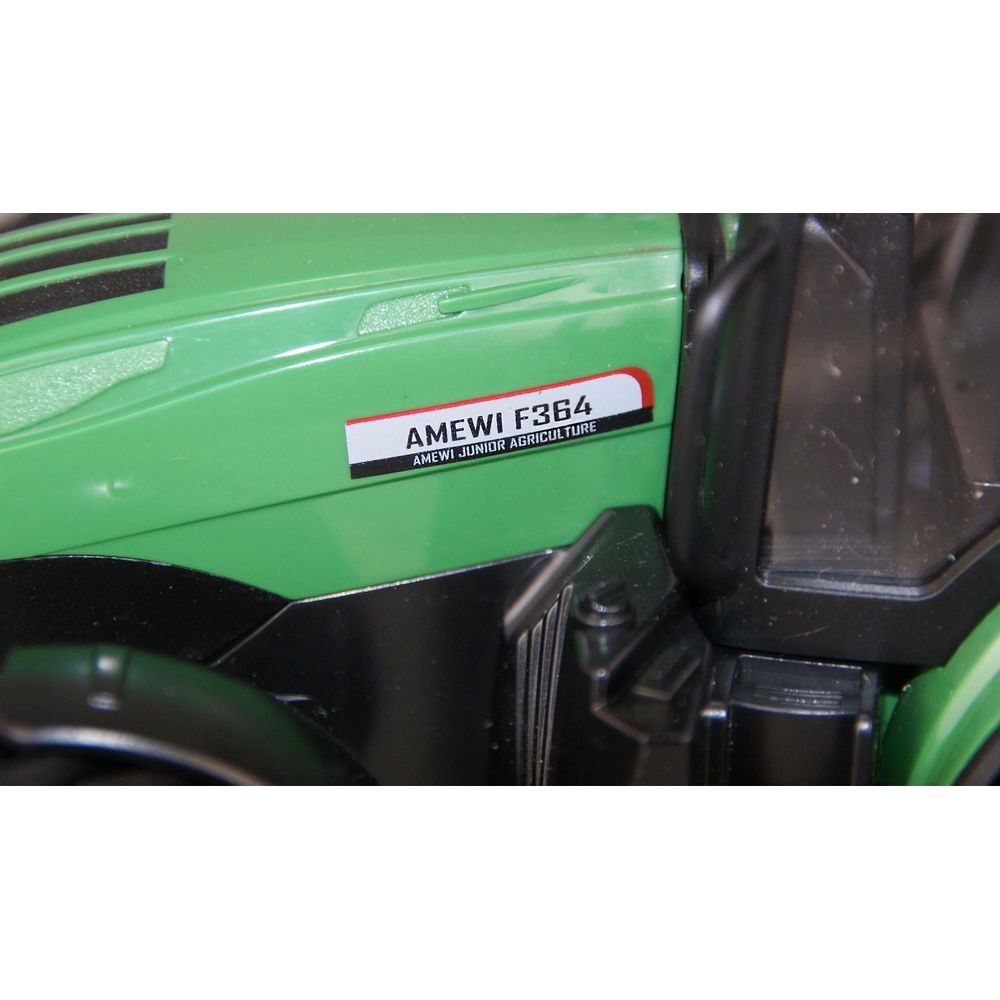 Nahaufnahme eines grünen Traktors mit schwarzem Schriftzug AMEWI F364 an der Seite.