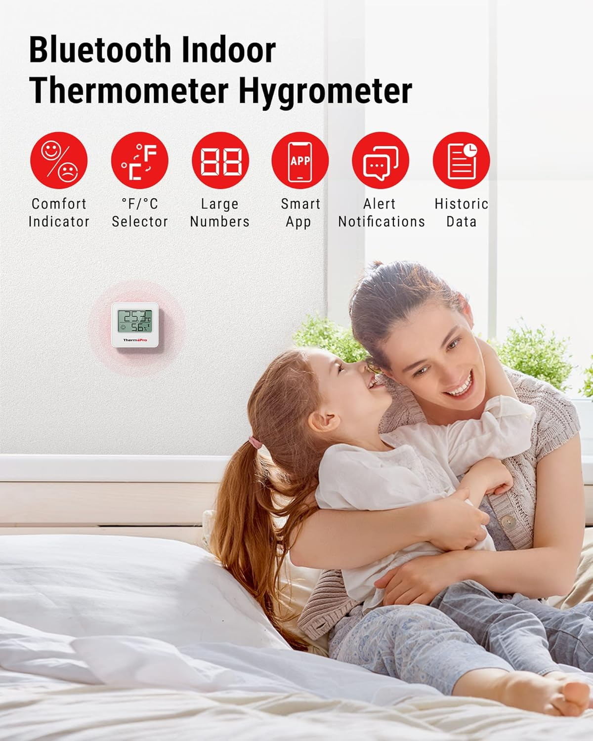 Eine Mutter umarmt ihr Kind auf einem Bett, darüber Werbeicons für ein Bluetooth-Thermometer.