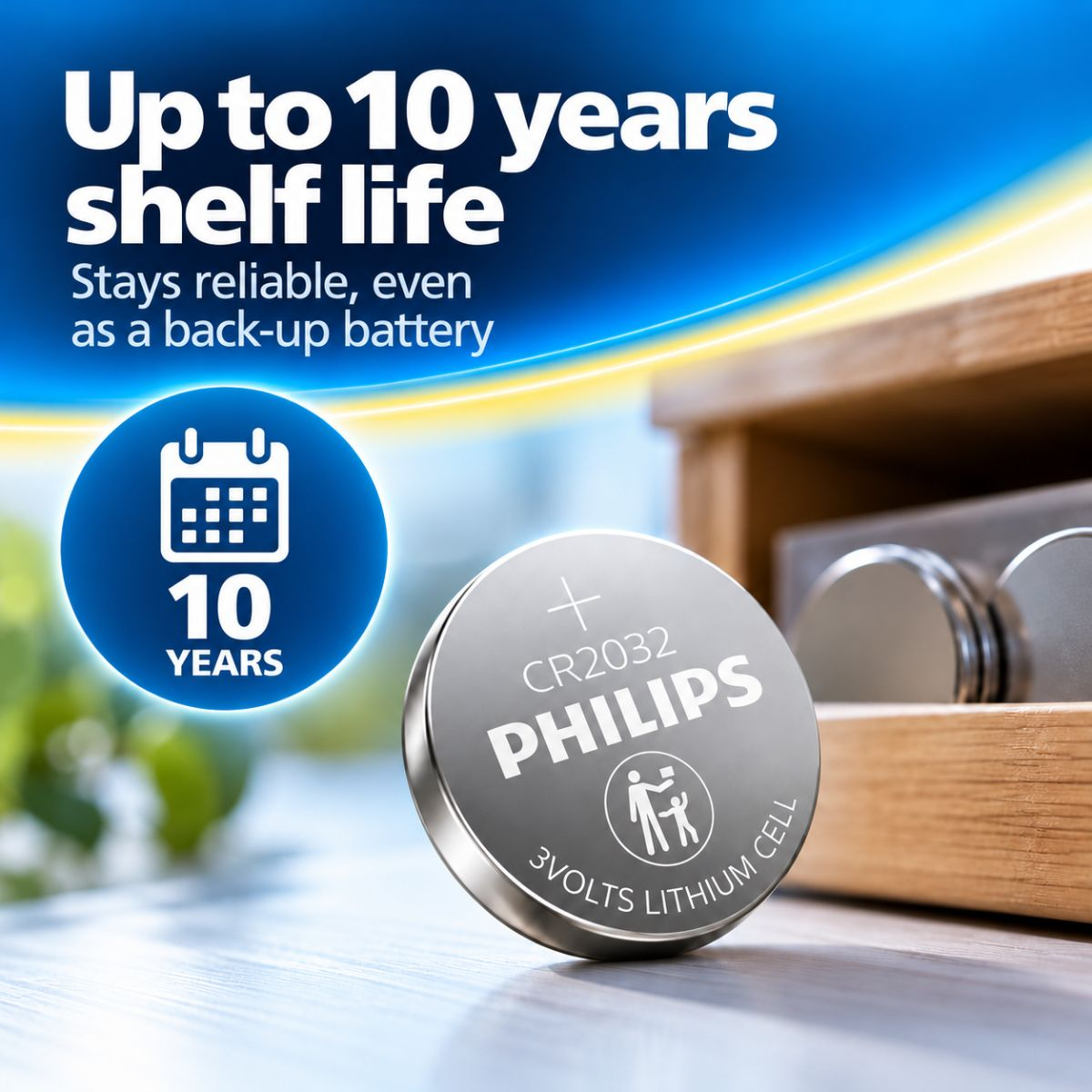 Una pila de botón de litio Philips CR2032 de 3V sobre una superficie de madera con texto sobre su vida útil de 10 años.