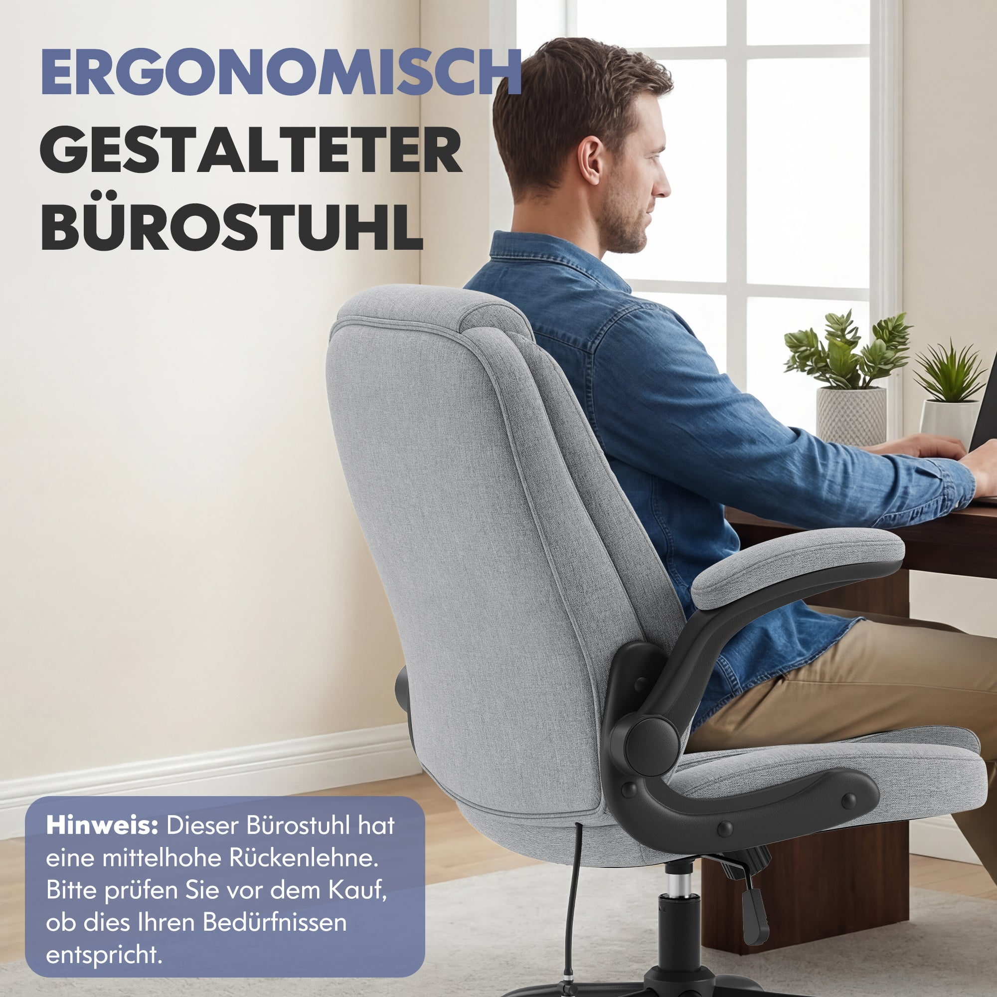 Ein Mann sitzt an einem Holztisch auf einem grauen Bürostuhl mit schwarzem Gestell.