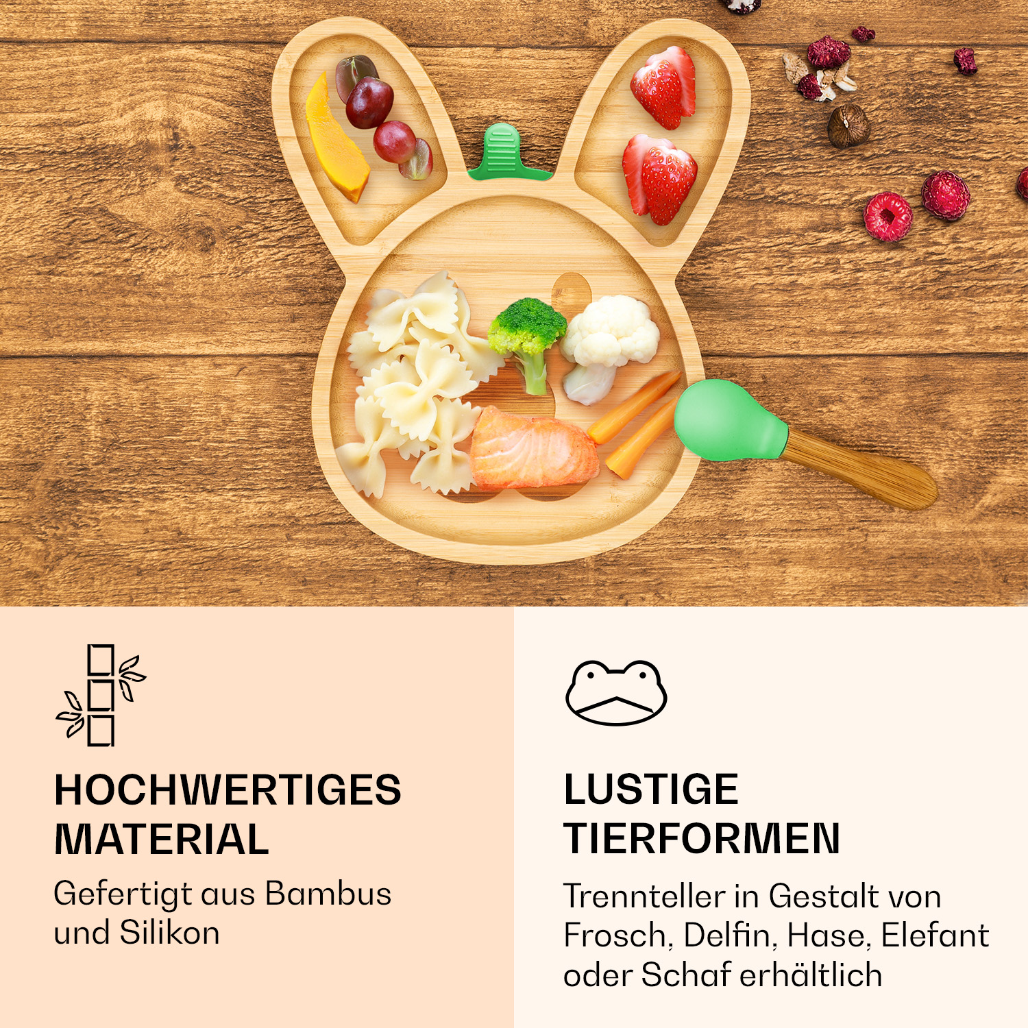 Bambus-Hasenteller mit Nudeln, Lachs, Gemüse und Früchten, dazu ein grüner Löffel auf Holzgrund.