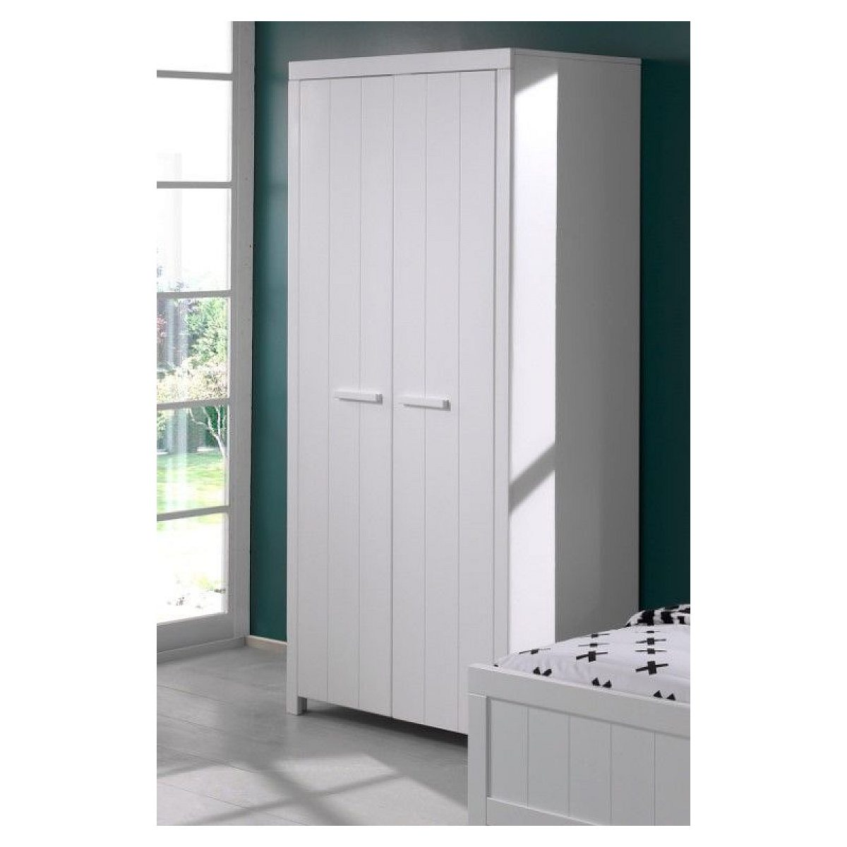 Ein weißer Kleiderschrank steht in einem Raum mit dunklen Wänden, einem Holzboden und einem Fenster.