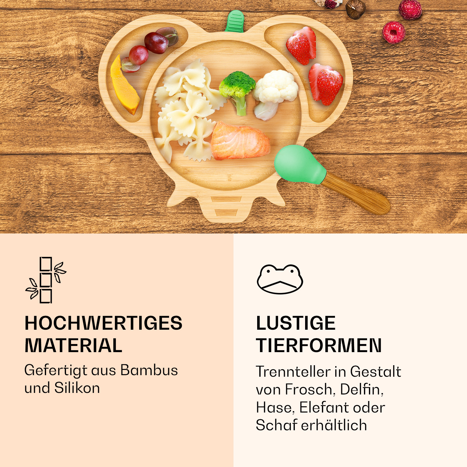 Ein tierförmiger Bambusteller mit Nudeln, Lachs, Gemüse und Obst neben einem grünen Löffel.