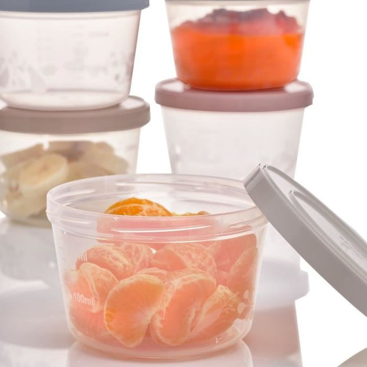 Stapelbare Plastikbehälter mit verschiedenen Früchten gefüllt, darunter Mandarinenstückchen und Bananen.