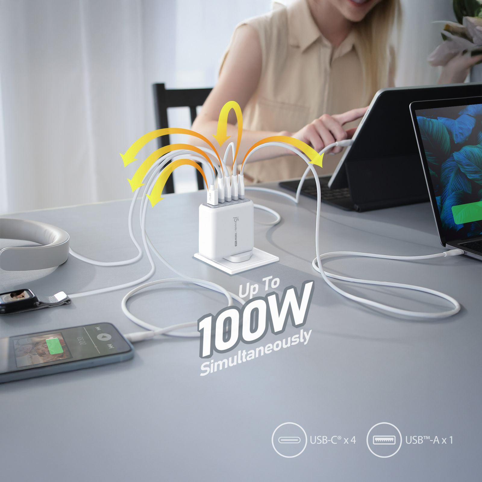 Ein weißes 100W-Ladegerät lädt mehrere Geräte gleichzeitig auf einem Tisch.