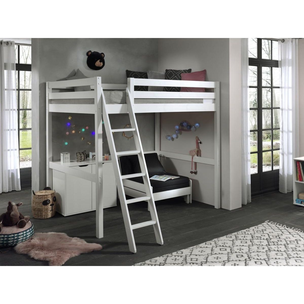 Weißes Hochbett mit Leiter, Schreibtisch und Sofa in einem gemütlichen Kinderzimmer mit großen Fenstern.