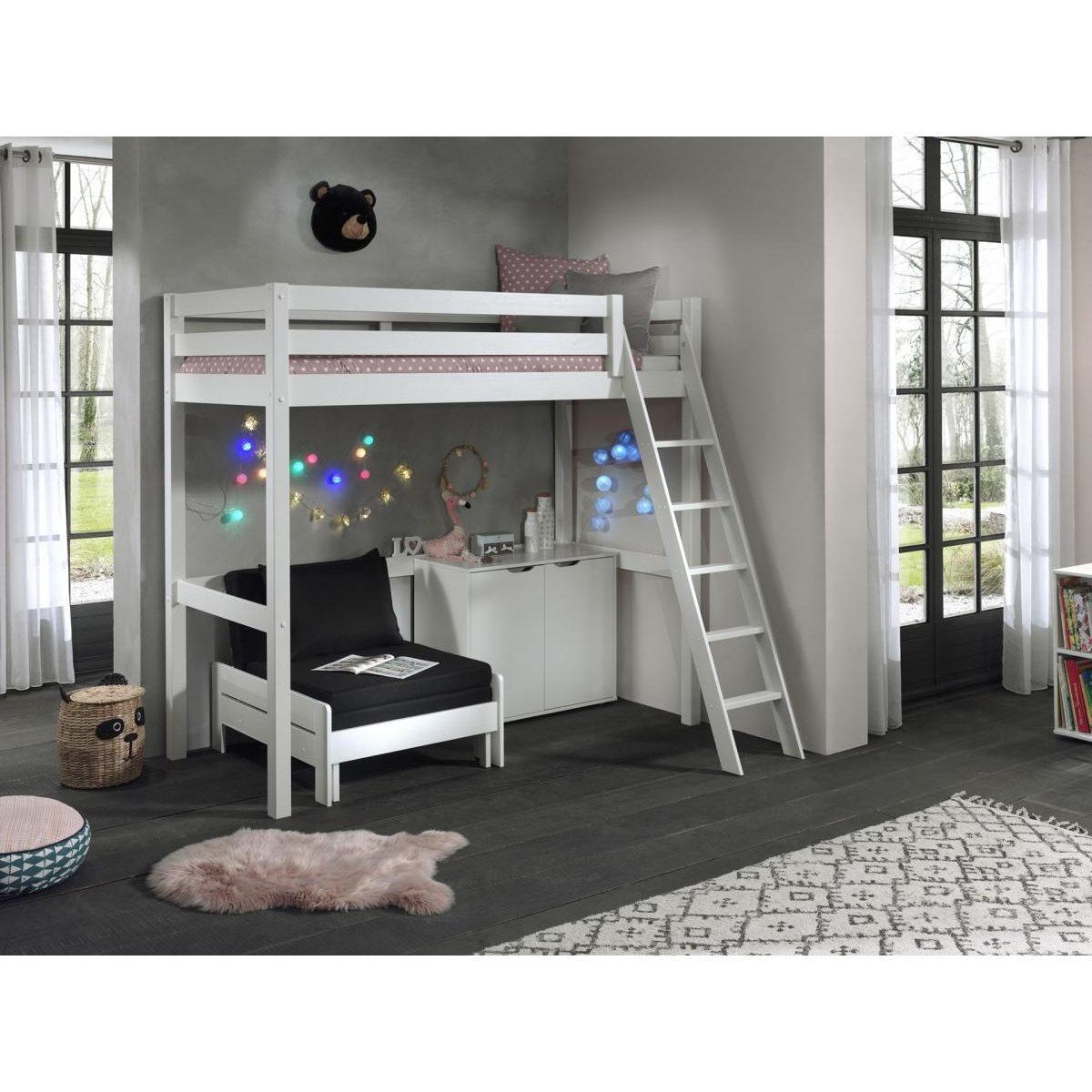 Ein weißes Hochbett mit schwarzem Sessel, Leiter und Lichterkette im Kinderzimmer.