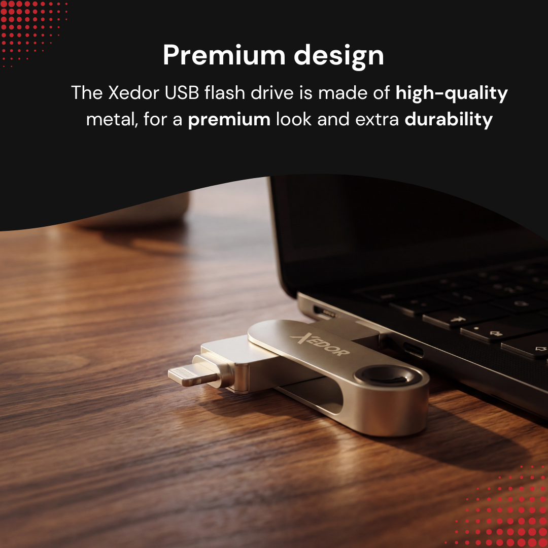 Srebrna pamięć USB Xedor na drewnianym stole obok laptopa. Tekst: Premium design.