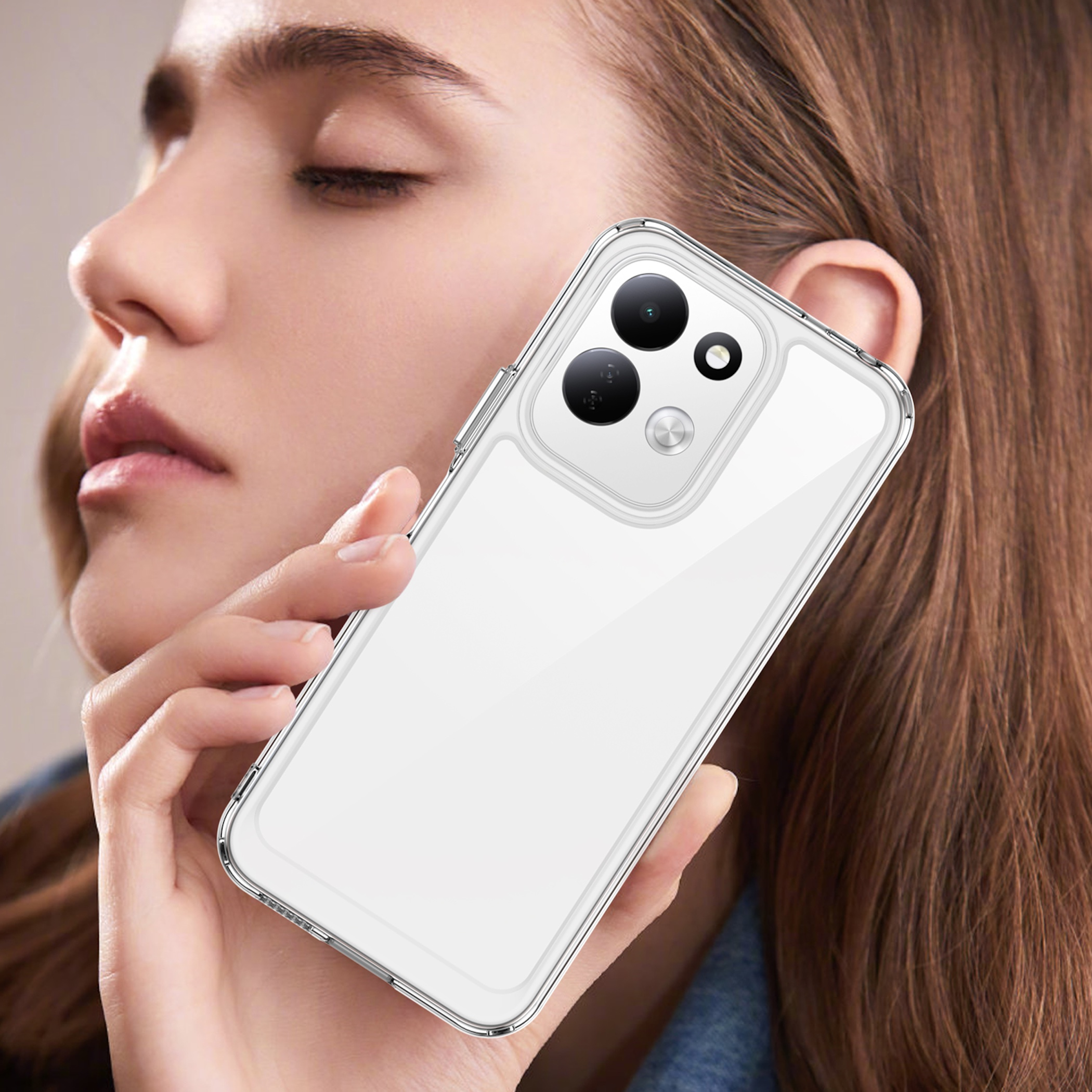 Eine Frau hält ein weißes Smartphone mit transparenter Hülle an ihr Gesicht.