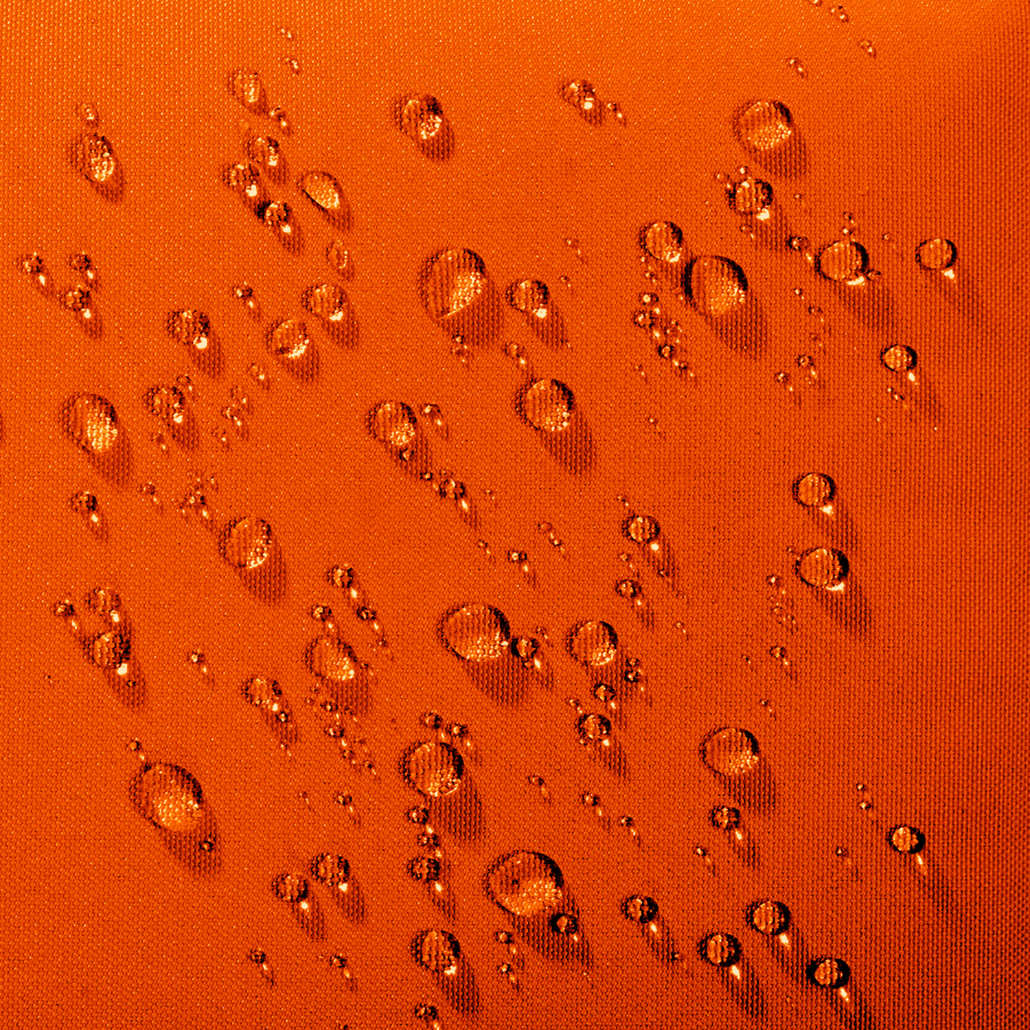 Wassertropfen auf einer strukturierten, orangen Stoffoberfläche.