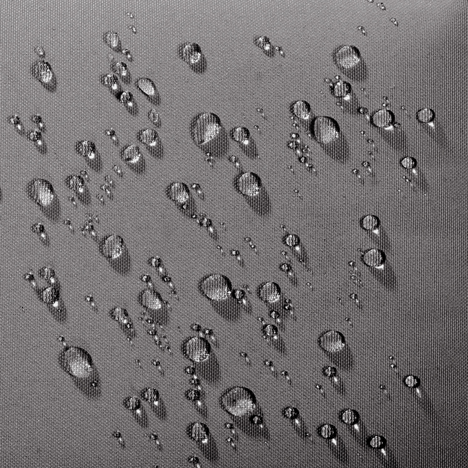 Wassertropfen auf einer grauen, wasserabweisenden Gewebeoberfläche.