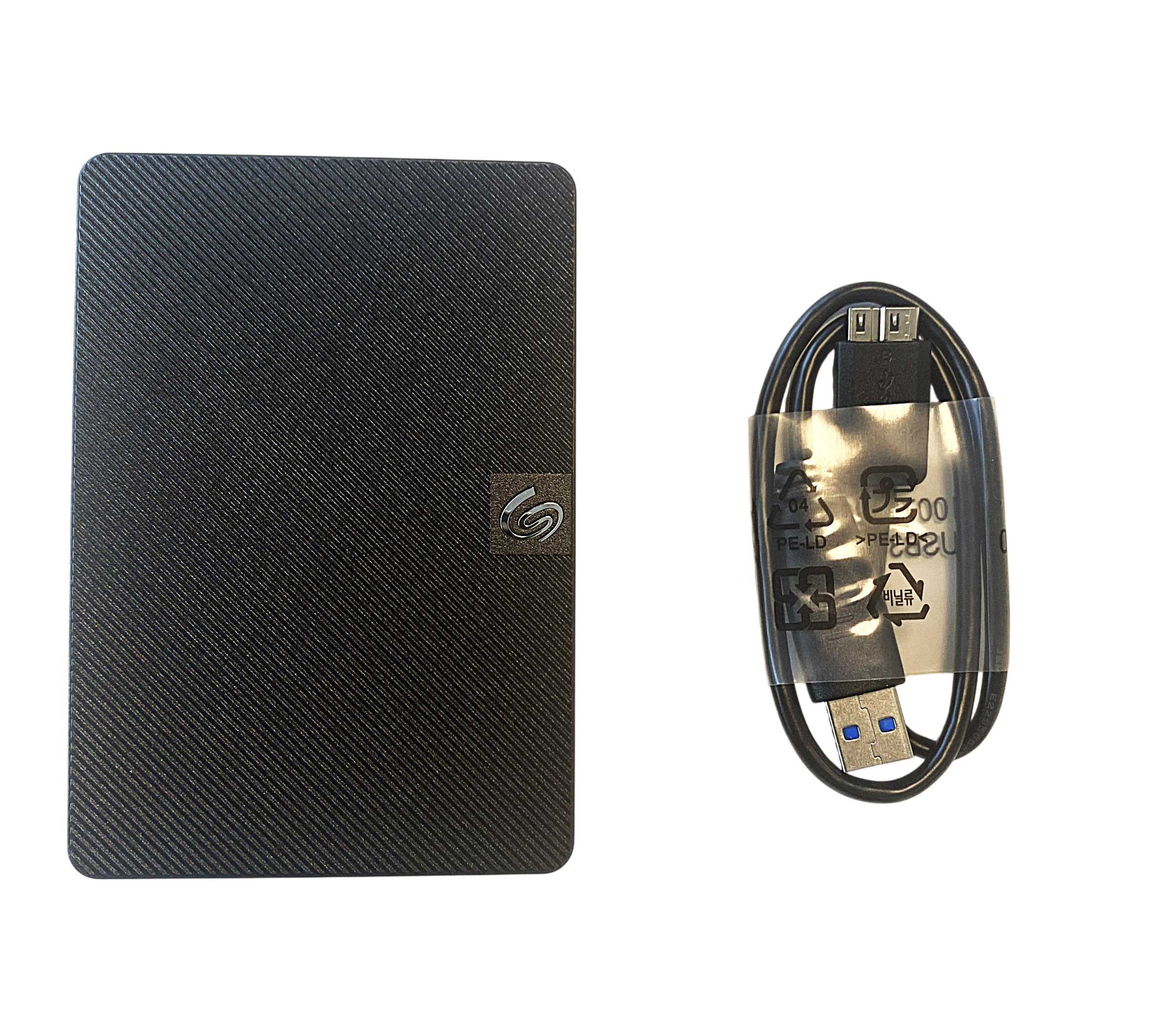 Eine schwarze Seagate-Festplatte mit Rillenmuster und ein zusammengerolltes USB-Kabel mit Plastikhülle.