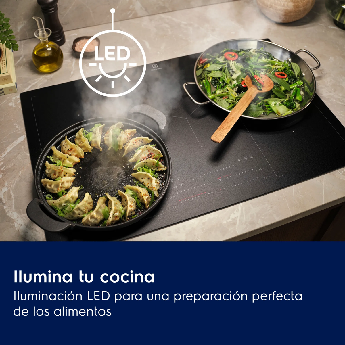 Placa de inducción LED con dos sartenes, una cocinando empanadillas y otra verduras.