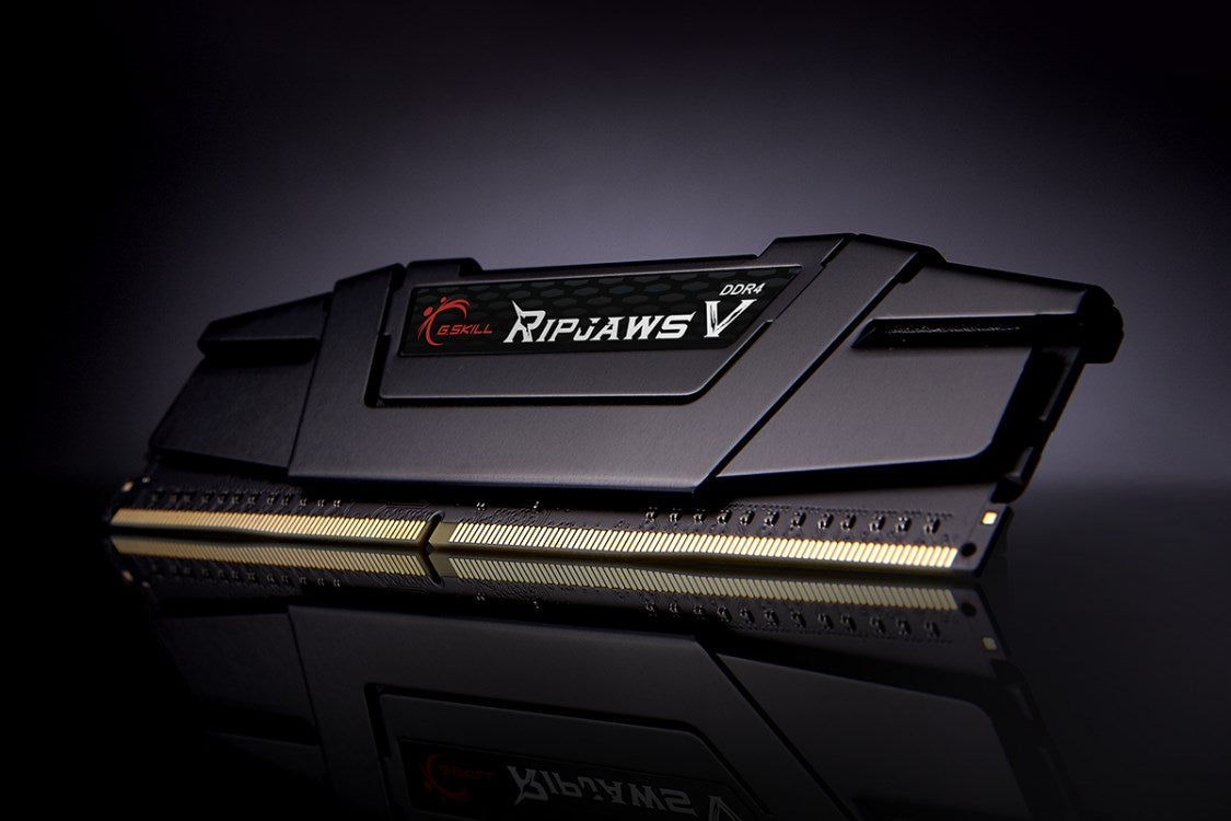 Ein schwarzer G.Skill Ripjaws V DDR4 RAM-Riegel auf einer reflektierenden dunklen Oberfläche.