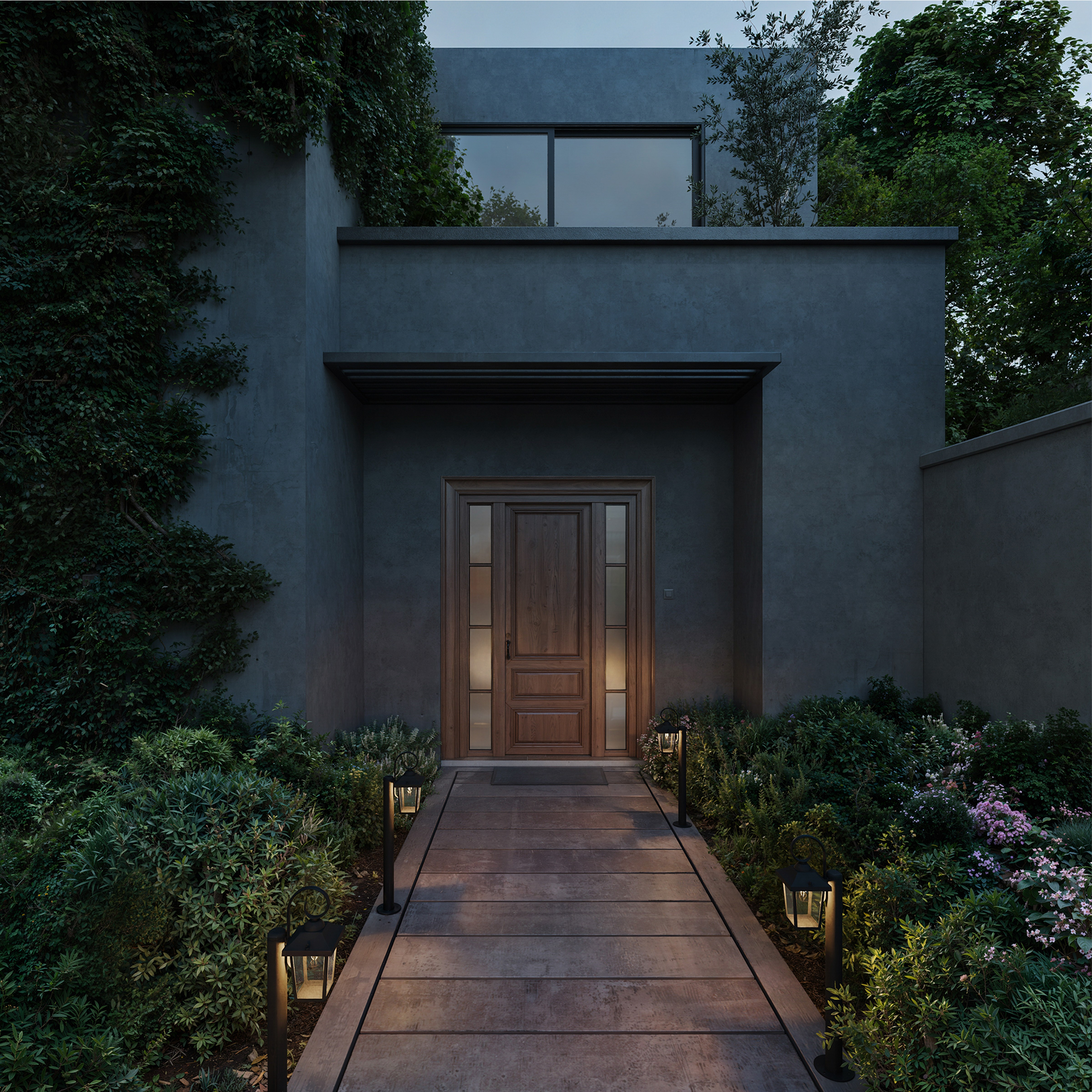 Un chemin en bois éclairé mène à la porte d'une maison moderne gris foncé, entourée de jardins et de lierre.