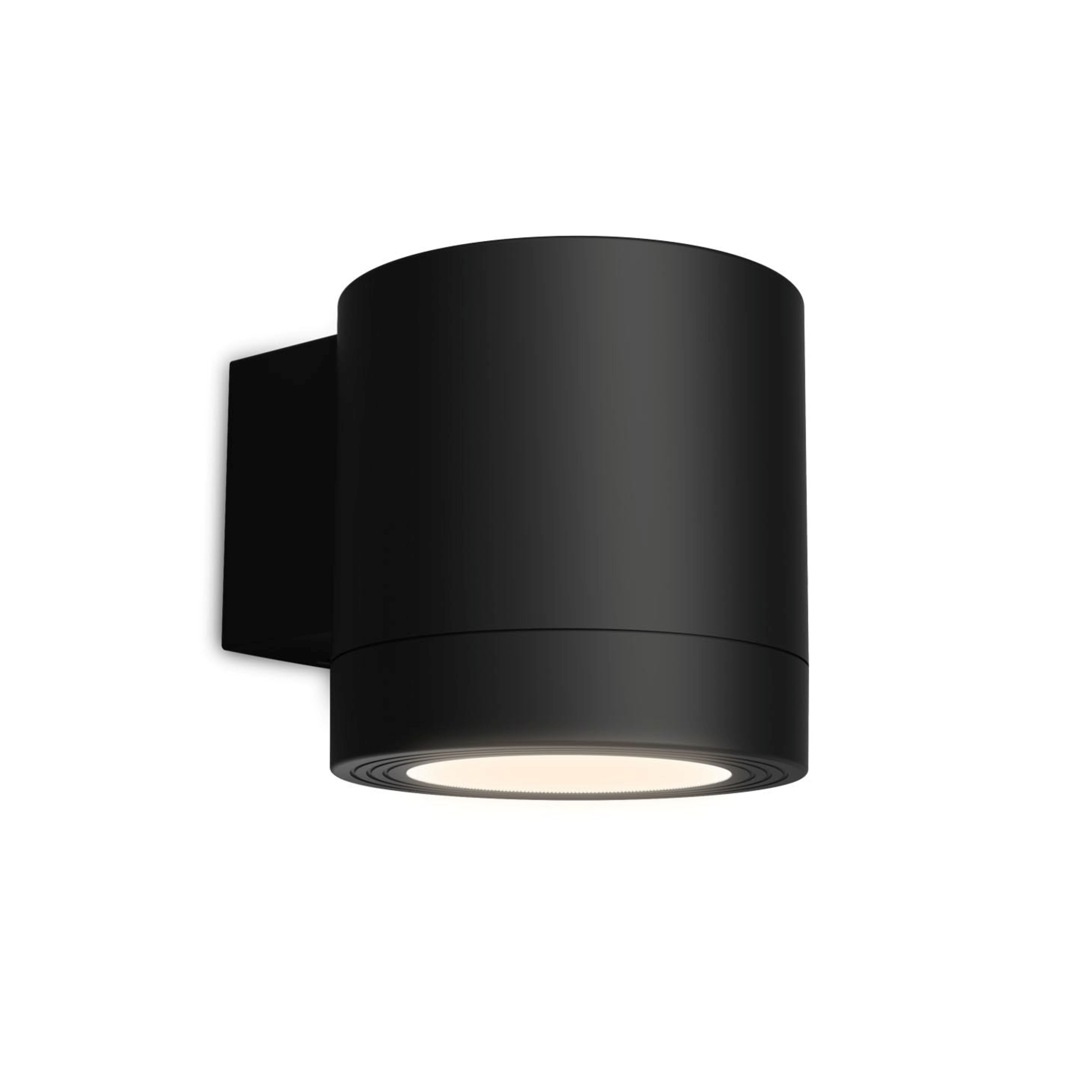 Een moderne, cilindrische zwarte wandlamp schijnt zacht licht naar beneden tegen een witte achtergrond.