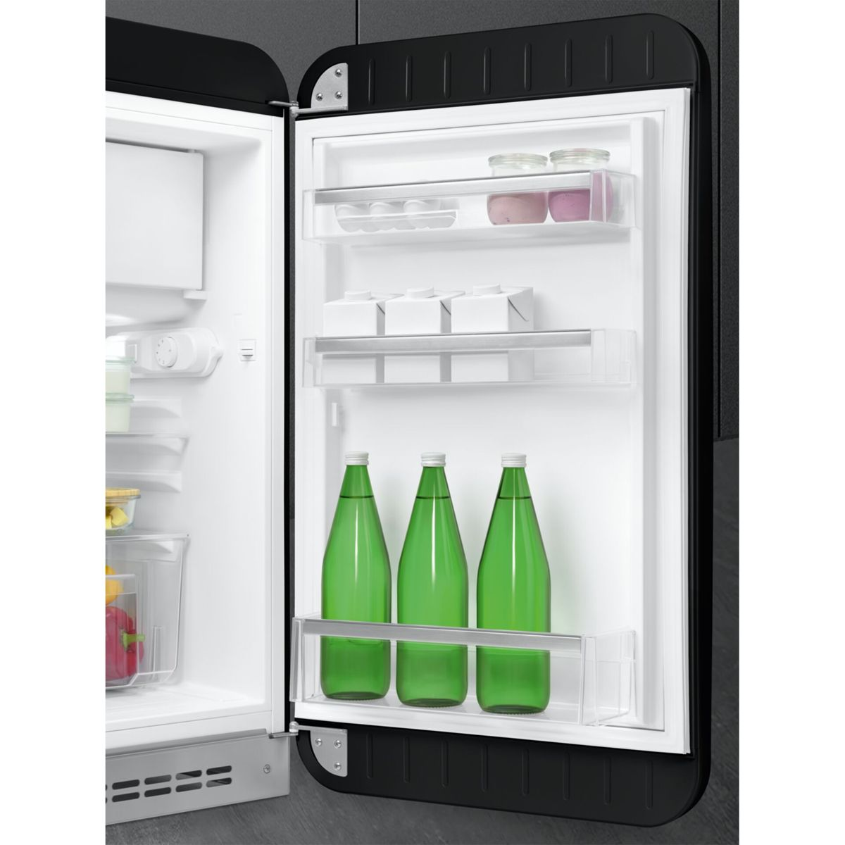 Refrigerador negro abierto con botellas y recipientes en los estantes de la puerta y comida dentro.
