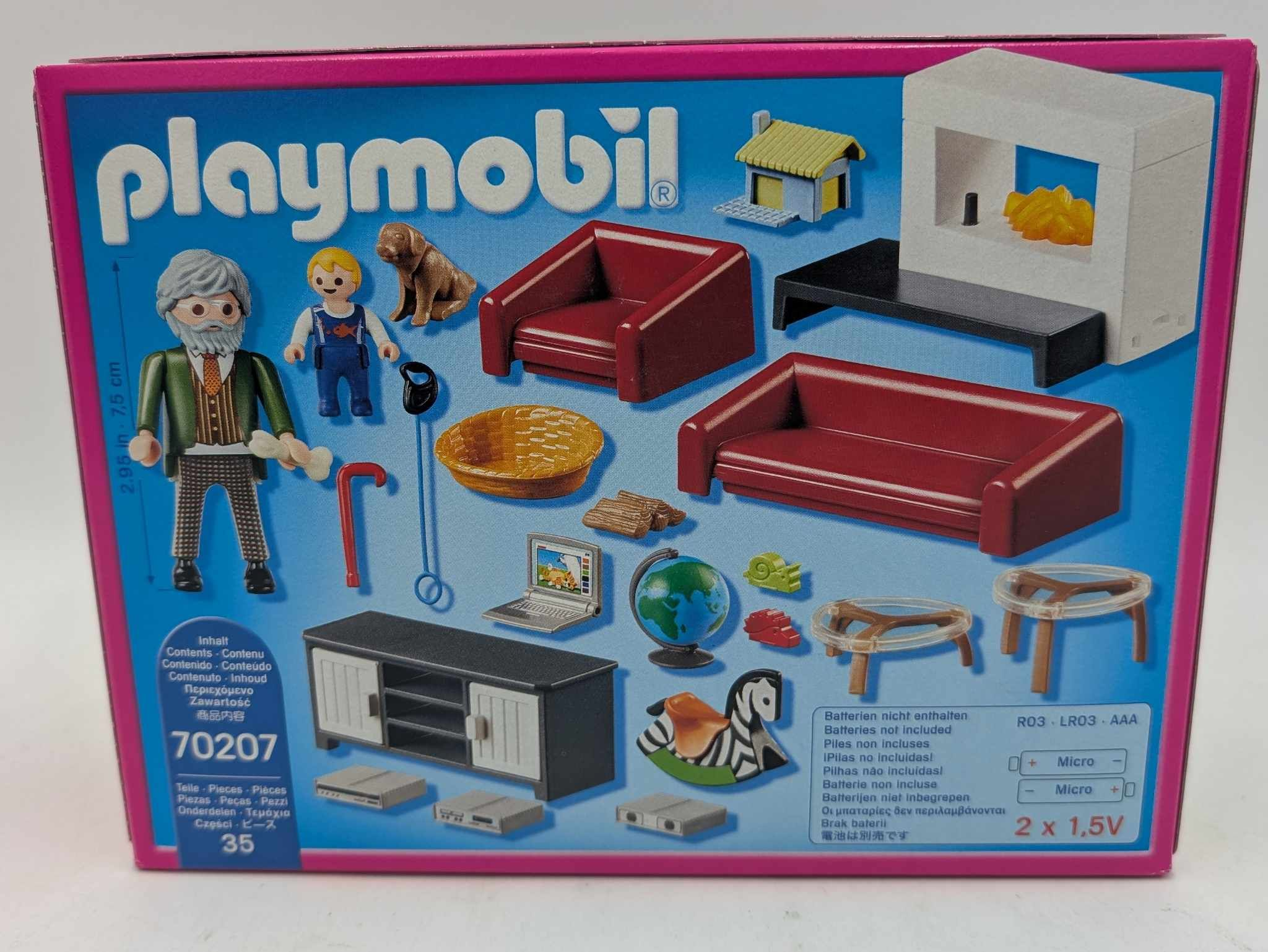 Una caja de juguetes Playmobil muestra figuras, muebles, una chimenea y accesorios sobre fondo azul.