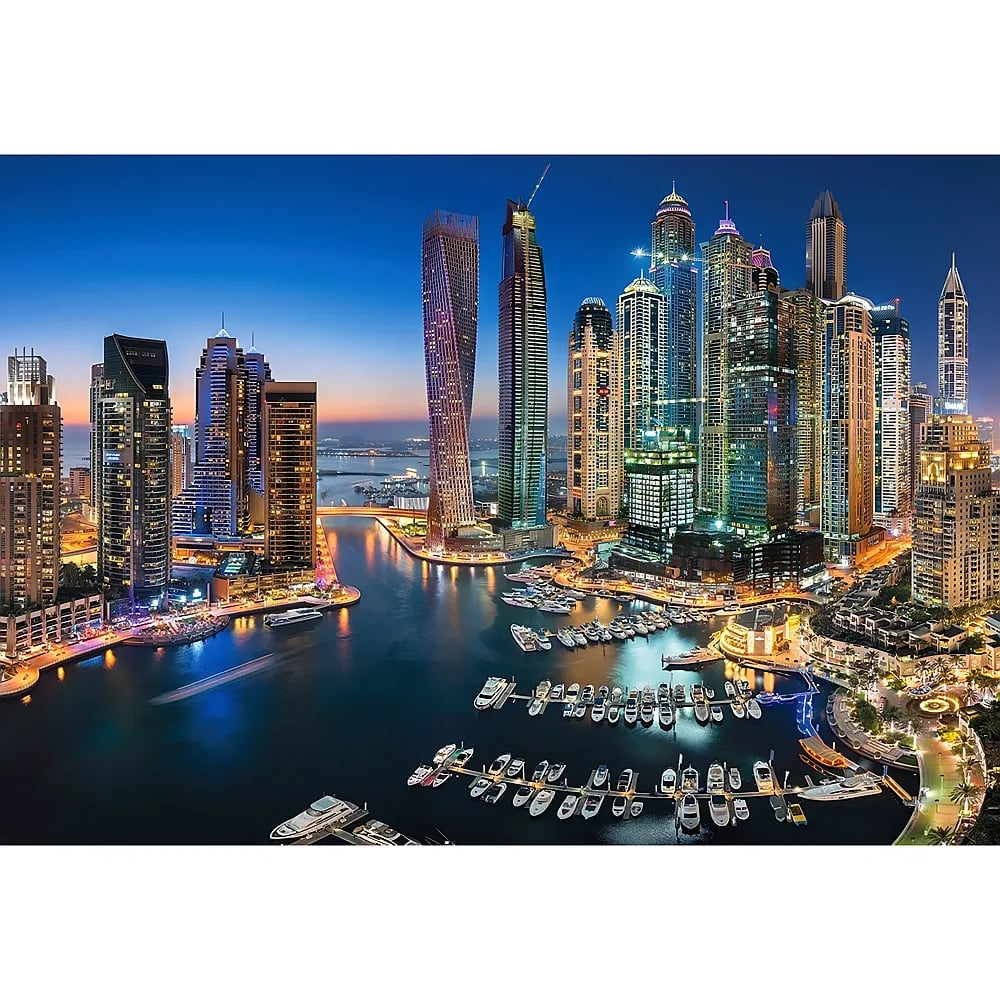 Beleuchtete Dubai Marina Skyline in der Dämmerung mit Wolkenkratzern und Booten.