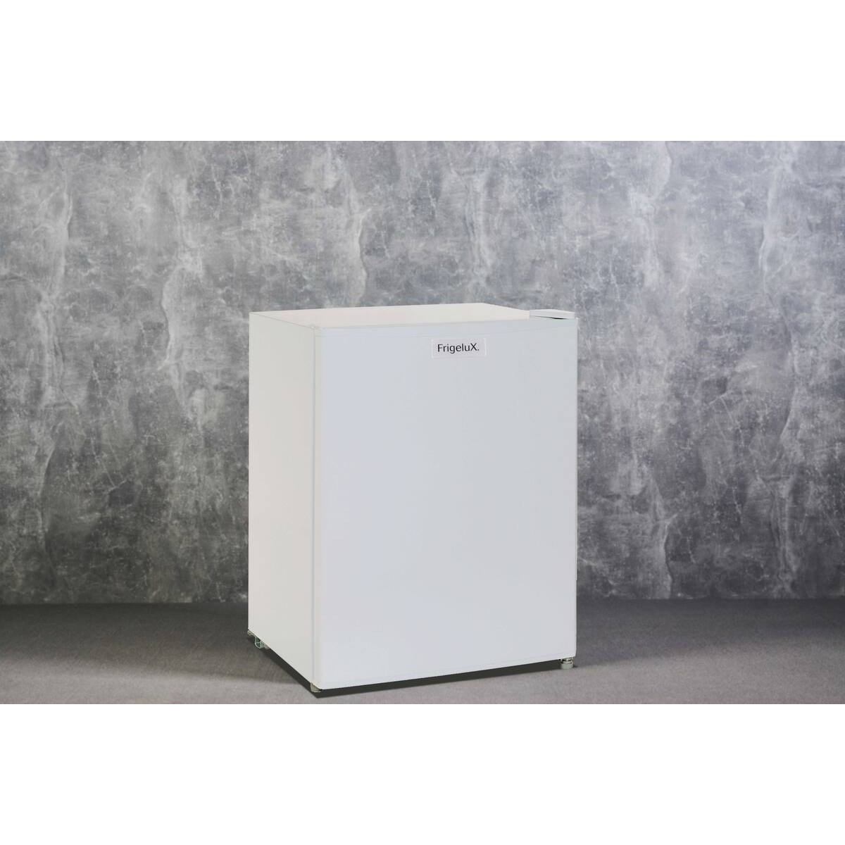 Un refrigerador compacto blanco con el logotipo de Frigelux se encuentra contra una pared de hormigón gris.