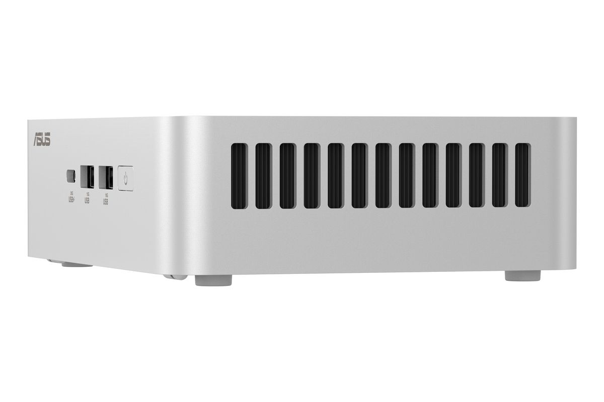 Mini PC ASUS plateado con puertos USB, ranuras de ventilación y botón de encendido.