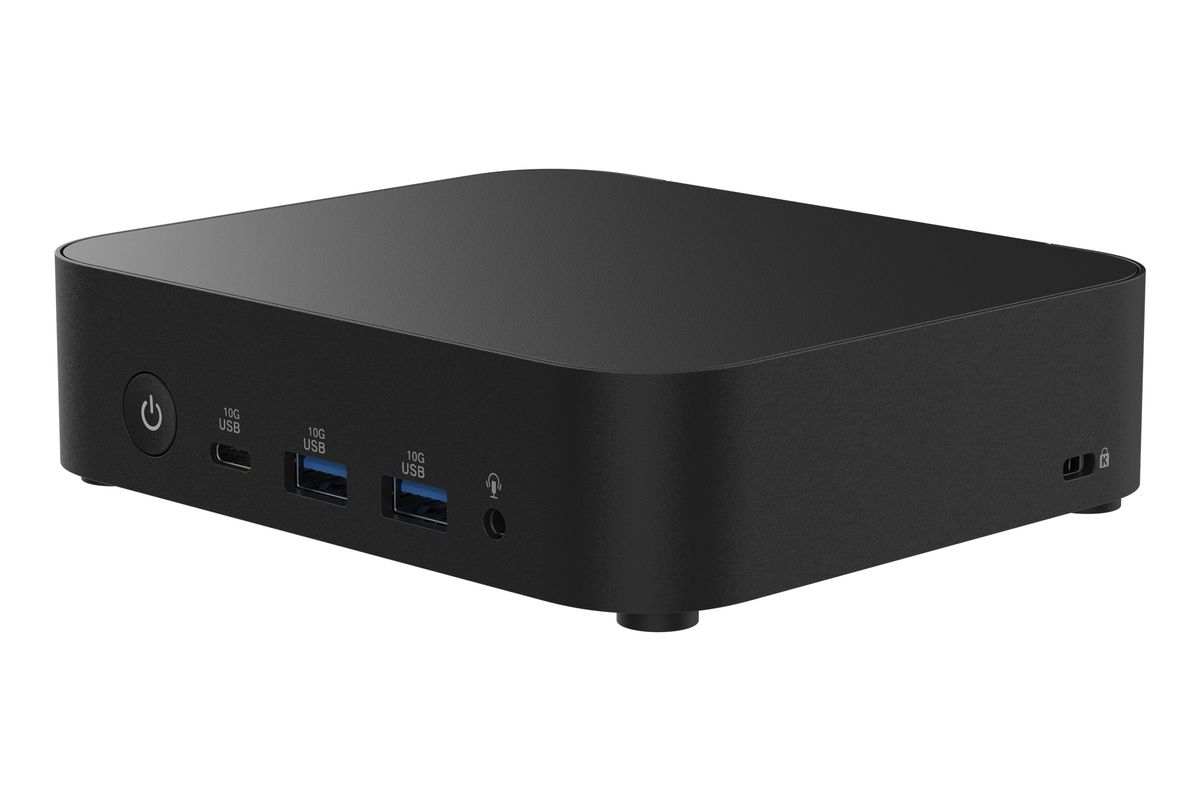Un mini PC negro con puertos frontales que incluyen USB, botón de encendido y conector de audio sobre fondo blanco.