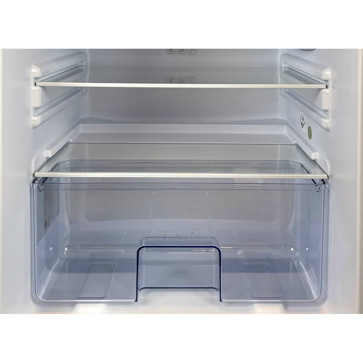 El interior de un frigorífico blanco con estantes vacíos y un cajón transparente.