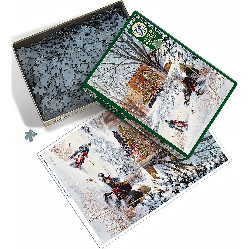 Ein offenes Cobble Hill 1000-Teile-Puzzle mit Eisläufern im Winter und losen Teilen in der Schachtel.