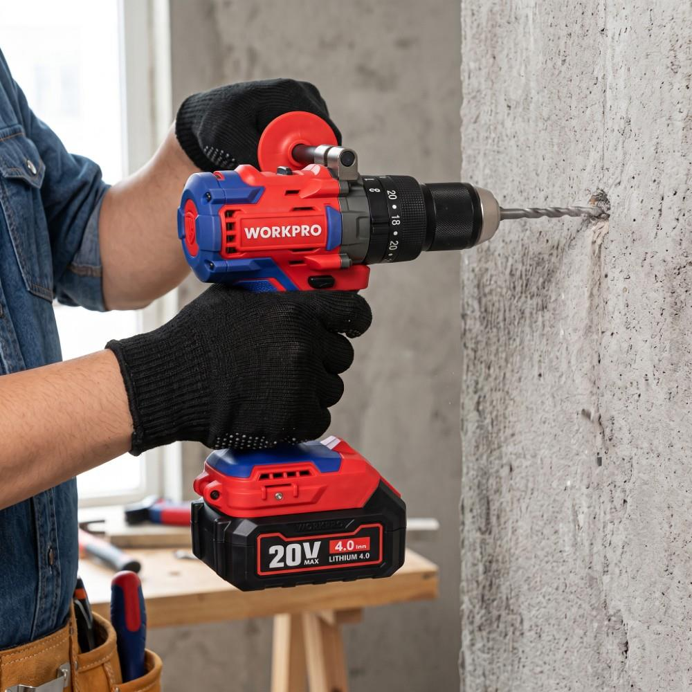 Bir kişi kırmızı ve mavi renkli WORKPRO akülü matkapla beton duvara delik açıyor.