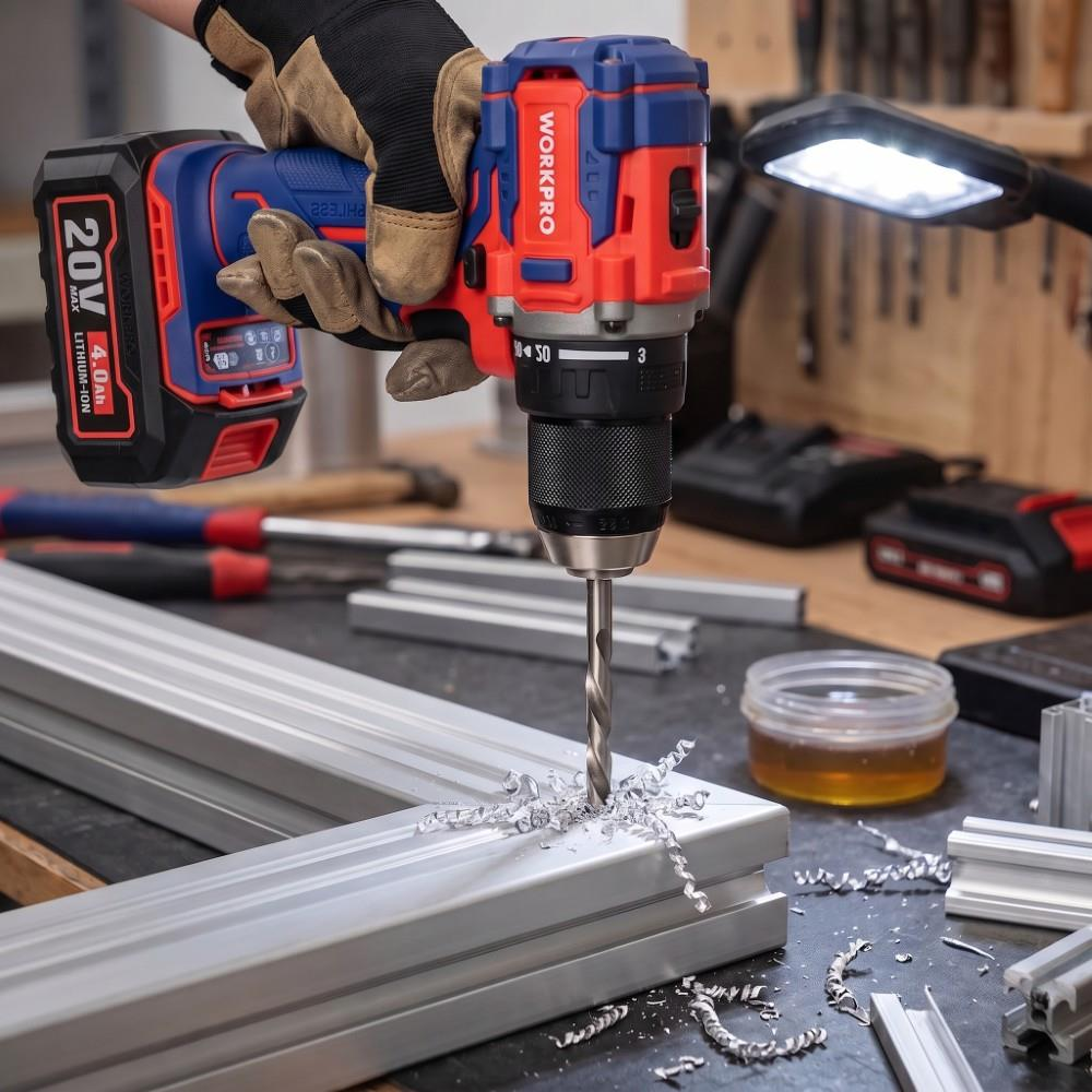 Eldivenli bir el kırmızı ve mavi matkapla metal profili deliyor, talaşlar saçılıyor.