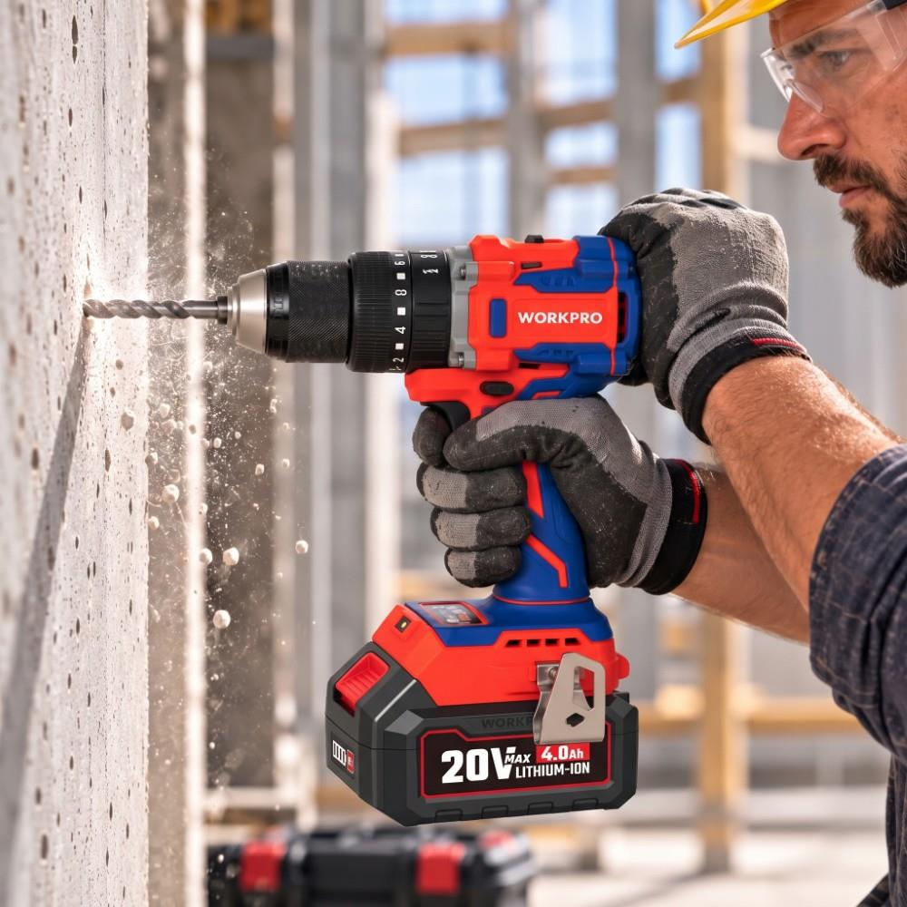 Baret ve eldiven giyen bir işçi, kırmızı ve mavi Workpro matkapla beton duvara delik açıyor.