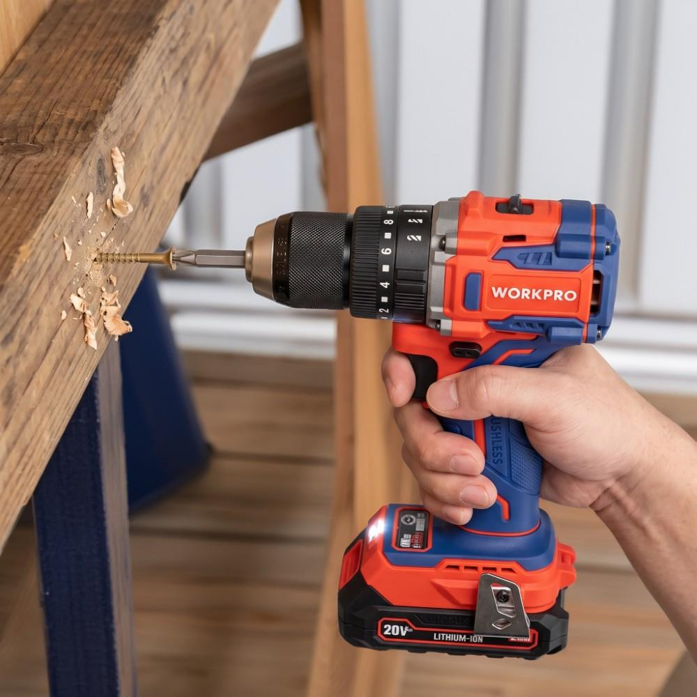 Bir kişi turuncu ve mavi Workpro akülü matkap tutarak ahşap bir kirişe vida takıyor.