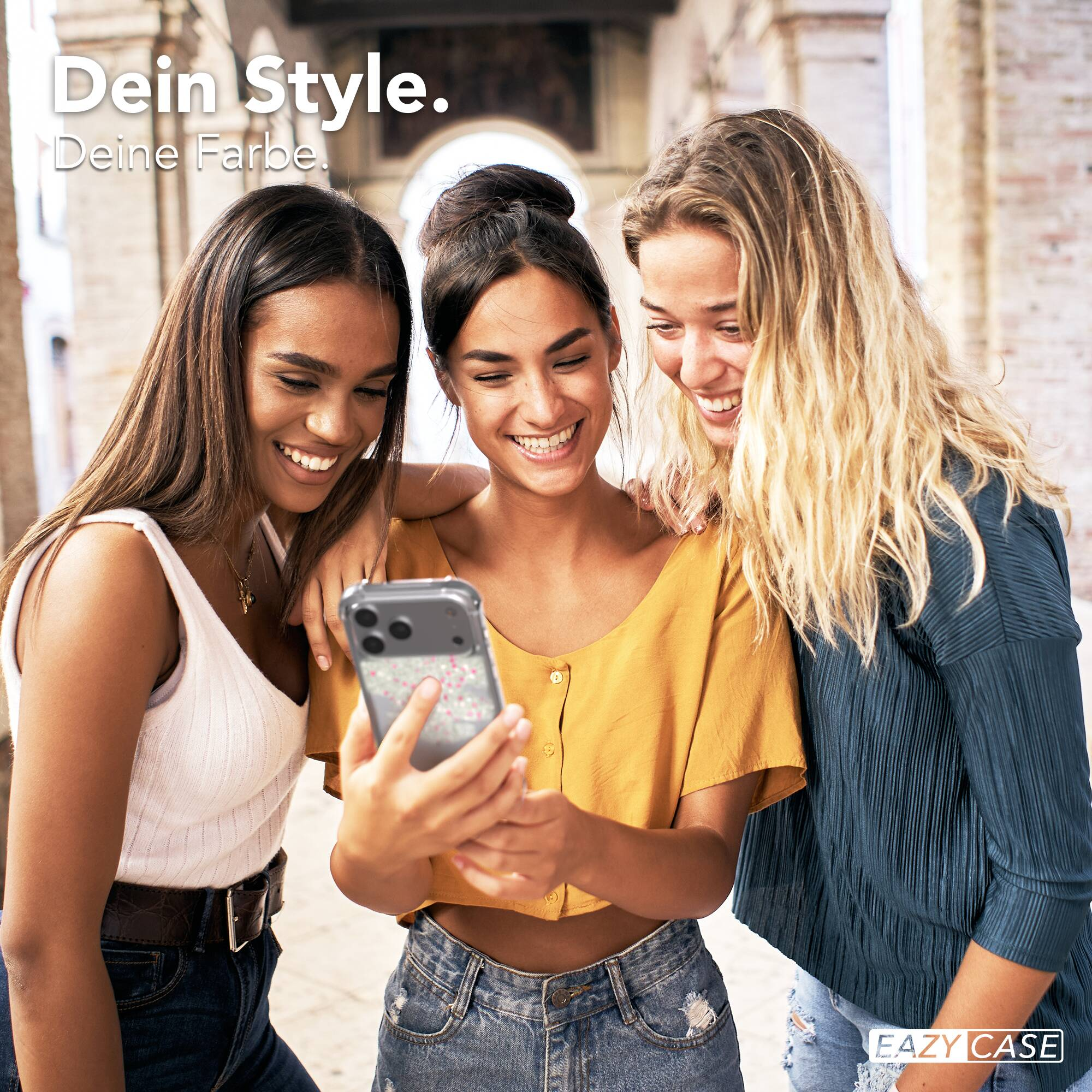 Drei glückliche junge Frauen schauen zusammen auf ein Smartphone. Text im Bild: Dein Style. Deine Farbe.