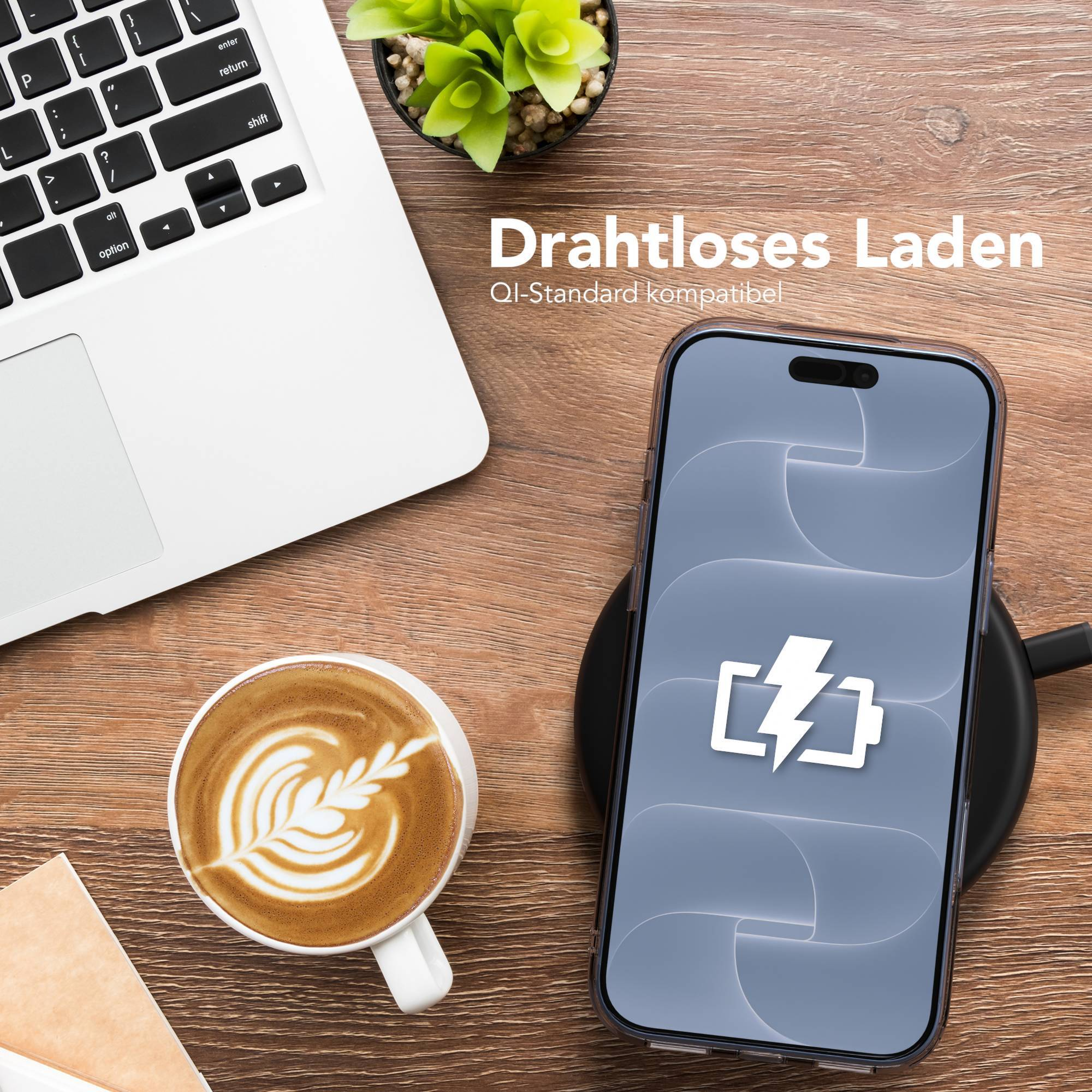 Smartphone lädt kabellos auf Holzschreibtisch mit Laptop, Kaffeetasse und Pflanze.