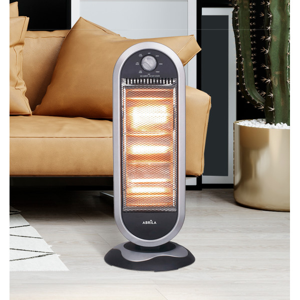 Un calefactor eléctrico plateado y negro sobre suelo de madera clara, con sofá y cactus al fondo.