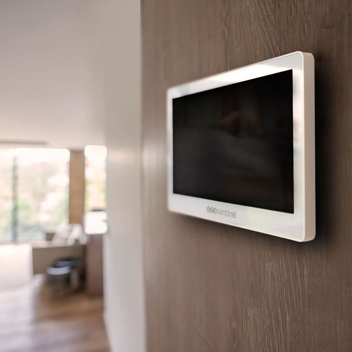 Ein weißer Monitor mit schwarzem Bildschirm ist an einer Holzvertäfelung an einer Wand montiert.